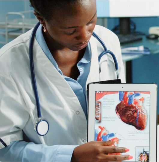 Female doctor holding a tablet with a heart diagram on the screen.