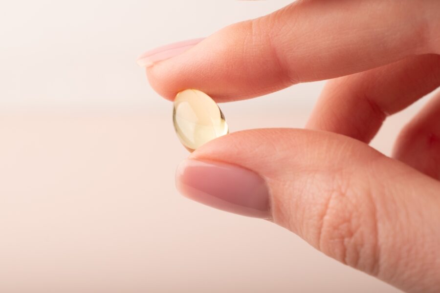 Assortment of vitamins and supplements commonly used for cholesterol management, including omega-3 capsules and vitamin tablets supporting heart health.