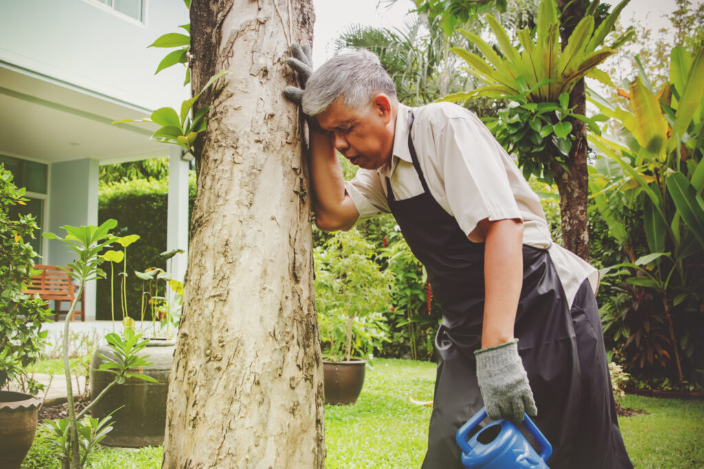 Elderly Man having a stroke outside while gardening.